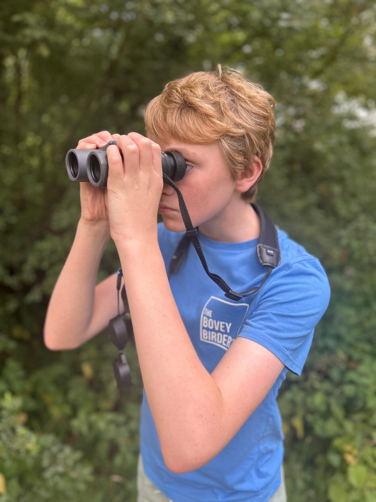 Henry looking through binoculars intently